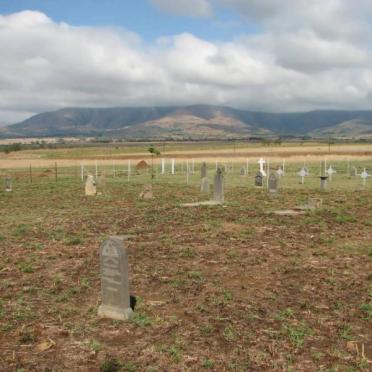 2. Overview on the farm cemetery with the military cemetery behind the fence